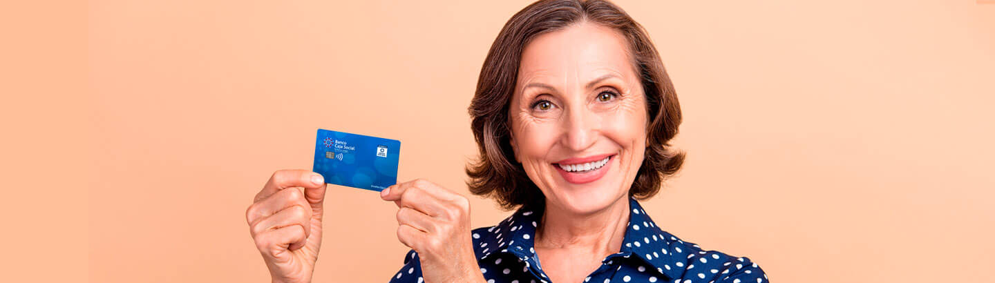 Mujer pensionada sonriendo con una tarjeta en sus manos